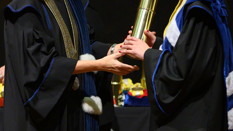 Um Diplomado a receber diploma, vê-se só parte do corpo.