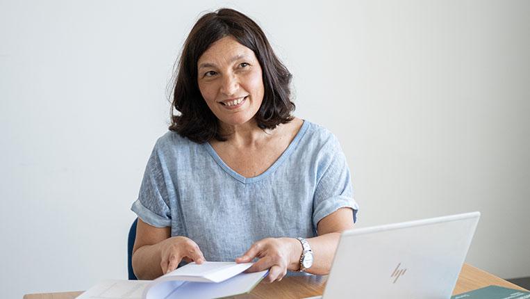 Paula Castro com computador e livros